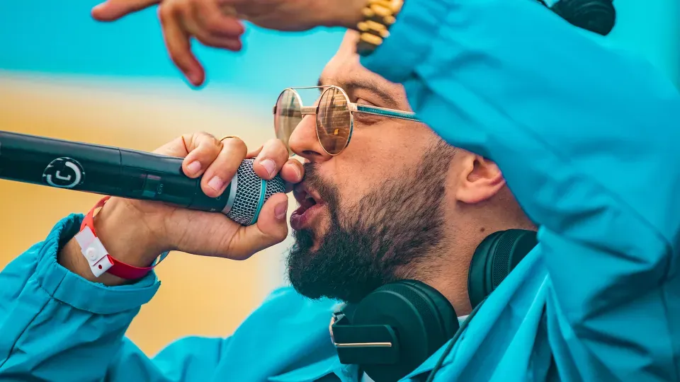 Een dj met microfoon en koptelefoon tijdens een optreden